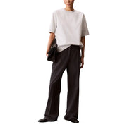 Black leather clutch bag paired with calvin klein jeans women grey round neck t shirt for stylish casual wear