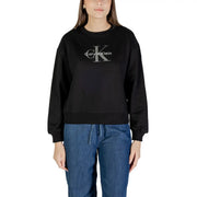 Woman wearing a black Calvin Klein long-sleeved sweatshirt and blue denim drawstring pants