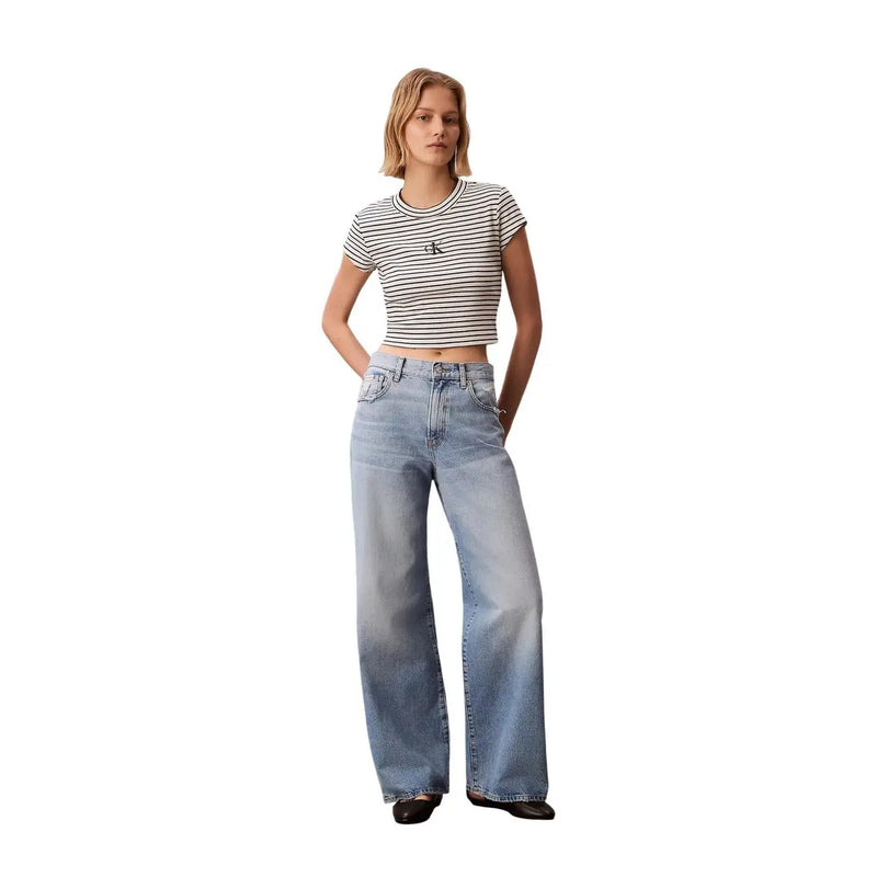 Un jean en denim clair à jambes larges et coupe classique cinq poches, associé à un t-shirt rayé noir à col rond Calvin Klein pour femme. top