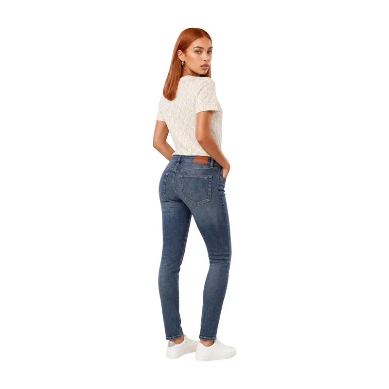 Jean en denim bleu à coupe slim et design classique à cinq poches, associé à un t-shirt blanc en coton à motifs géométriques Calvin Klein Jeans pour femme.