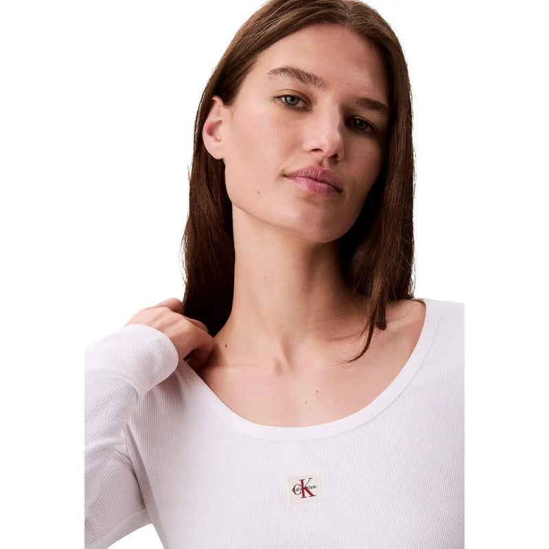 T-shirt blanc côtelé à manches longues en coton lycra top avec de petites broderies Calvin Klein logo sur la poitrine pour femmes