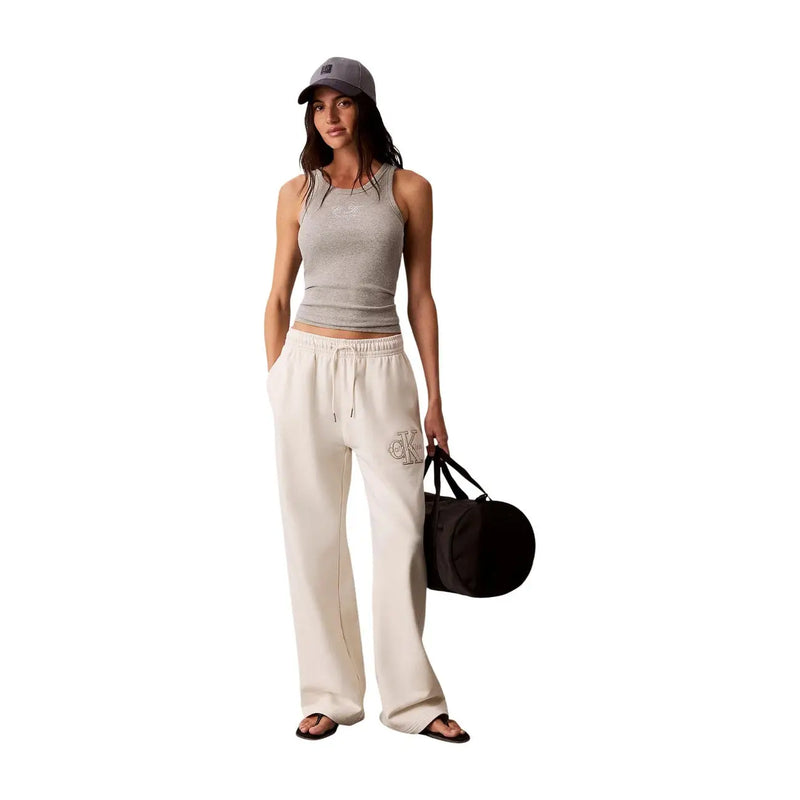 Sac de sport cylindrique noir avec poignées noires présenté à côté Calvin Klein Jeans Pantalon blanc en coton pour femme avec lacets