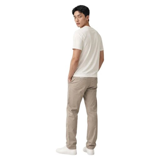 Un homme portant du coton beige Calvin Klein un pantalon et un blanc t-shirt montrant la face avant du produit