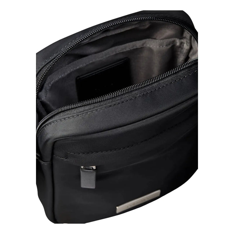 Calvin Klein Sacoche de reporter pour homme en nylon noir épuré, au design minimaliste et élégant, ornée de détails métalliques argentés.