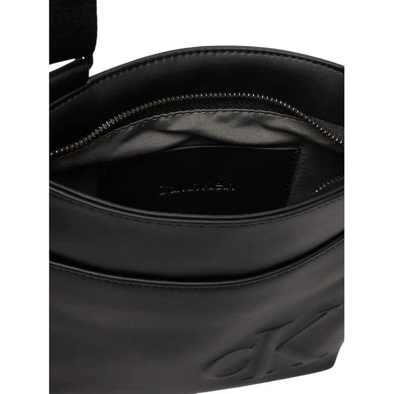 Sac bandoulière Calvin Klein pour homme, en polyuréthane noir, avec logo en relief et intérieur zippé.