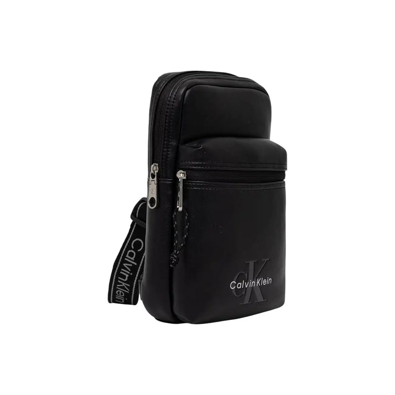 Sac bandoulière Calvin Klein pour homme, en toile noire avec logo audacieux, design minimaliste élégant et fermetures éclair argentées.