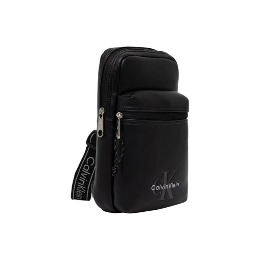 Sac bandoulière Calvin Klein pour homme, en toile noire avec logo audacieux, design minimaliste élégant et fermetures éclair argentées.