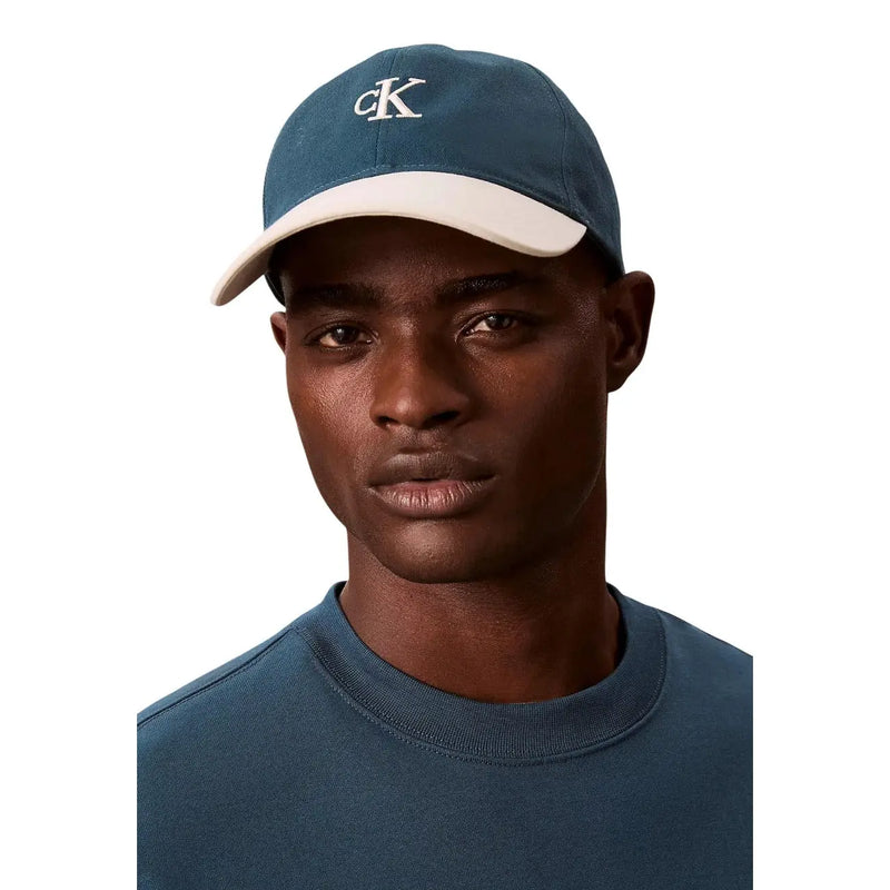 Casquette de baseball bicolore bleue et crème avec logo CK brodé en blanc, 100 % coton. Calvin Klein