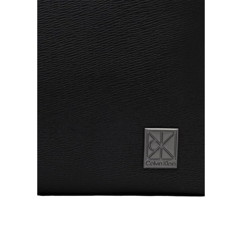 Portefeuille en cuir noir texturé avec des détails argentés Calvin Klein plaque logo montrée avec Calvin Klein Sac à dos homme à rabat avec emblème, en polyuréthane noir, taille W29