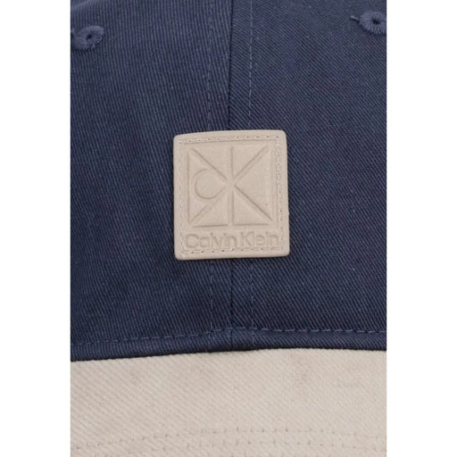 Casquette en denim bleu marine et coton avec écusson logo Calvin Klein en cuir beige, issue de la collection colorblock Calvin Klein Homme.
