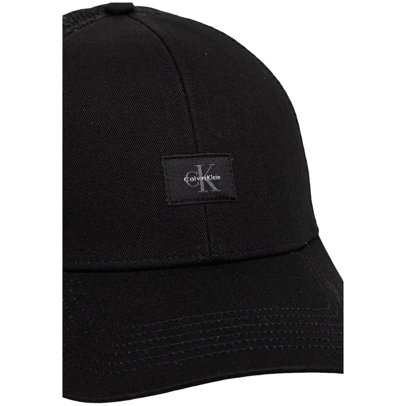 Calvin Klein Casquette trucker homme en coton noir monologo, avec tissu légèrement texturé et petit logo brodé noir.