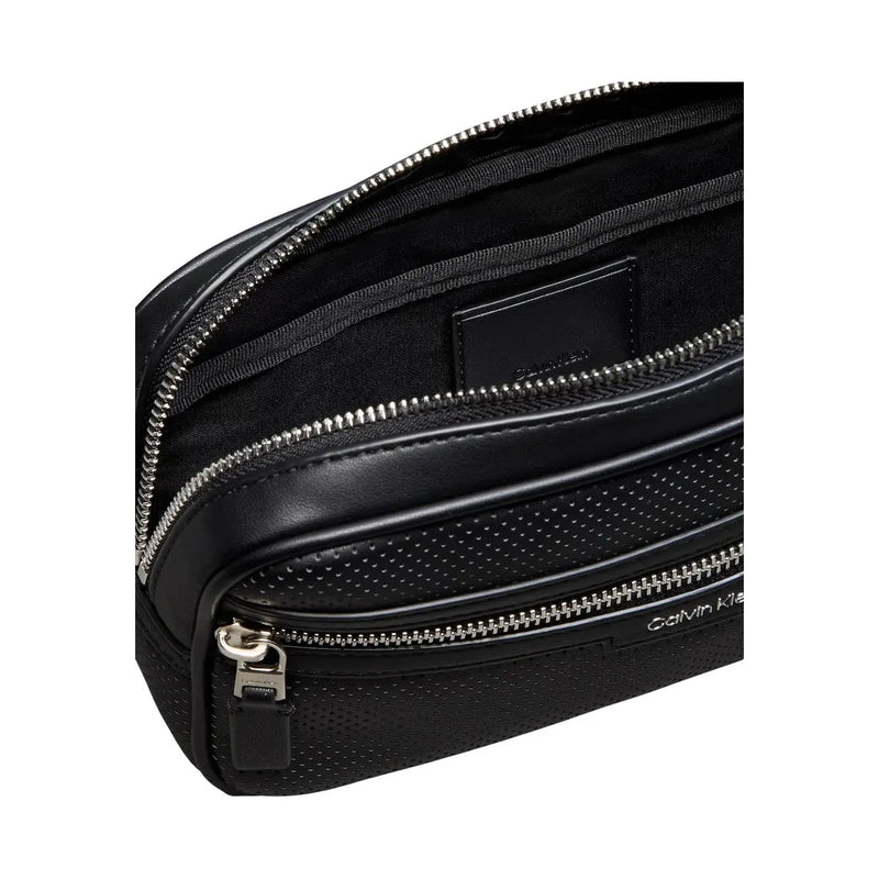 Calvin Klein Sac bandoulière noir perforé pour homme, en polyuréthane avec fermetures éclair argentées et design compact