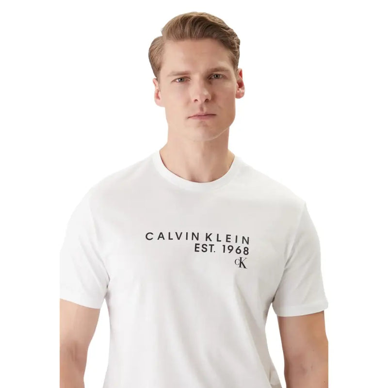 Calvin Klein T-shirt homme blanc en coton, col rond, imprimé Calvin Klein noir sur le devant, idéal pour une tenue décontractée.