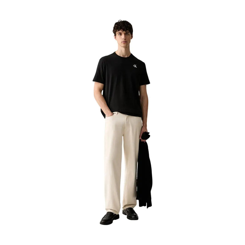 Calvin Klein T-shirt noir en coton pour homme, coupe classique, avec un petit logo blanc sur le devant de la poitrine.
