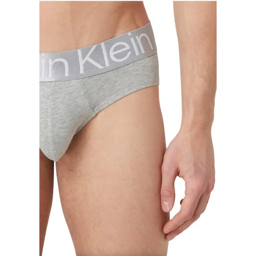 Slip Calvin Klein pour homme, gris chiné, avec ceinture élastique assortie et logo Calvin Klein blanc.
