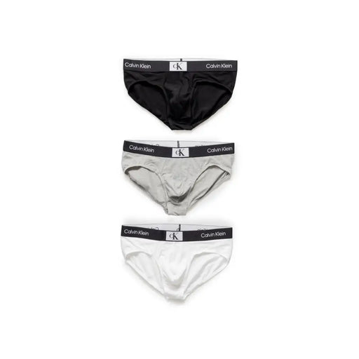 Ensemble de trois Calvin Klein Slips pour hommes noirs, gris et blancs, conçus pour le confort et un usage quotidien.