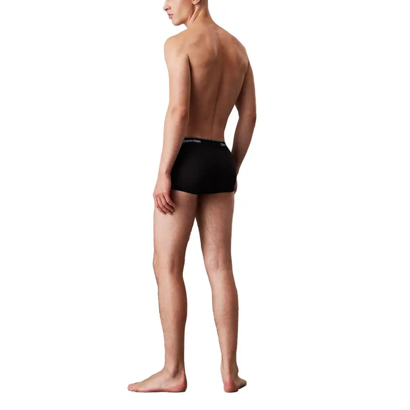 Slip noir Calvin Klein pour homme, orné d'un discret logo blanc sur la ceinture, conçu pour le confort et le style.