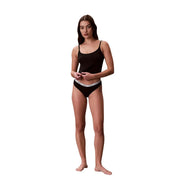 Calvin Klein Lot de 3 culottes brésiliennes en coton noir pour femme, avec ceinture élastique blanche et logo de la marque.