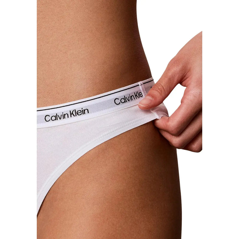 Culottes blanches Calvin Klein en coton avec bande logo noire, présentées dans un lot de 3 culottes bikini noires en coton pour femme.
