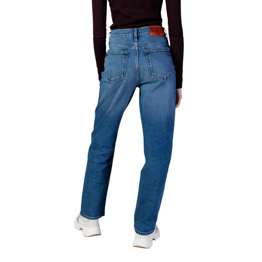Calvin Klein Jean femme en denim bleu clair, coton délavé moyen, coupe droite, avec étiquette de marque en cuir marron à la taille.