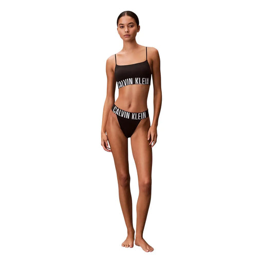 Ensemble bikini string Calvin Klein noir pour femme, échancré, en polyester et élasthanne, avec logo blanc. top et ceinture