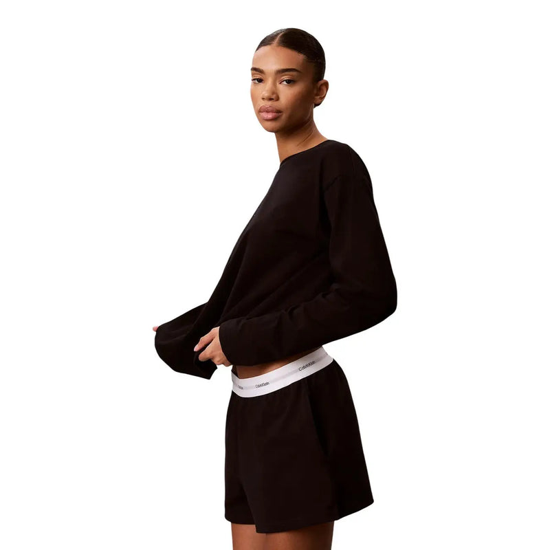 Calvin Klein Short en jersey de coton noir à logo pour femme, porté avec un haut court noir à manches longues. top avec des poignets côtelés