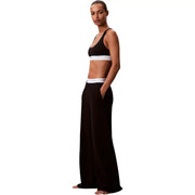 Pantalon large en jersey de coton noir pour femme, avec une ceinture blanche à logo Calvin Klein, idéal pour la lingerie.