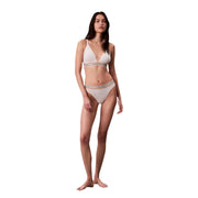 Une femme portant un bikini triangle blanc en coton légèrement doublé, avec des bretelles élastiques à logo Calvin Klein.