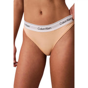 String beige Calvin Klein en polyester, avec ceinture blanche et logo Calvin Klein noir visible au dos