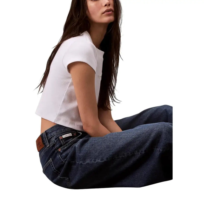 Dark blue denim jeans with brown leather brand patch on waistband from Calvin Klein women’s fall winter collection back view