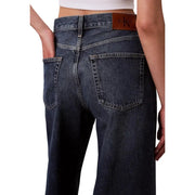 Back side of dark-wash denim calvin klein women’s bordeaux jeans with classic pocket design and leather brand patch
