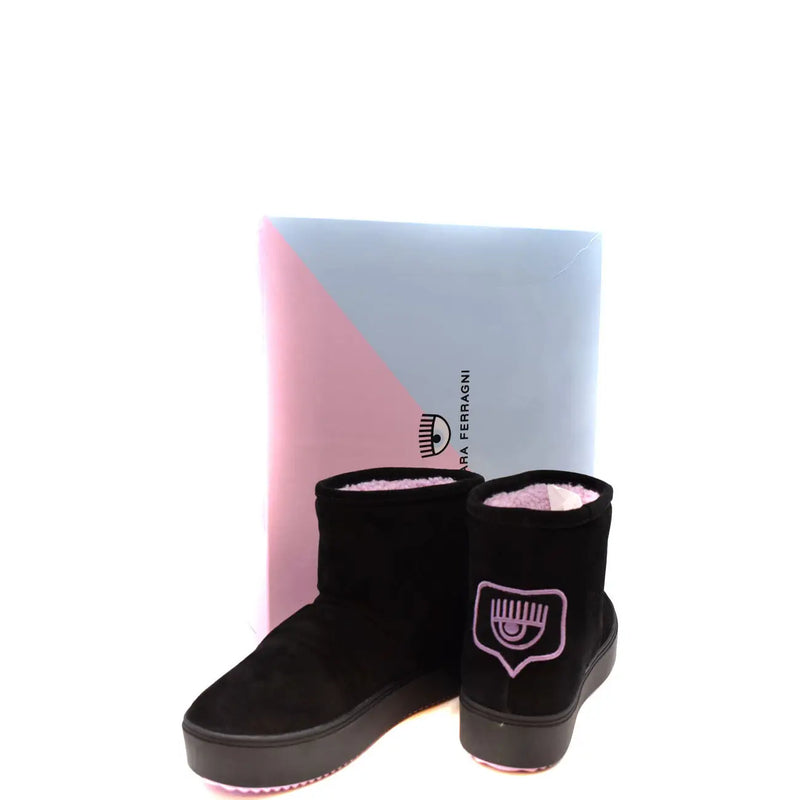 Bottines en daim noir avec logo œil brodé rose de Chiara Ferragni présentées devant une boîte de la marque