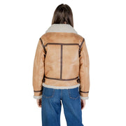 Tan shearling bomber jacket with plush white fleece collar cuffs and dark brown leather trim, paired with beige polyester blazer