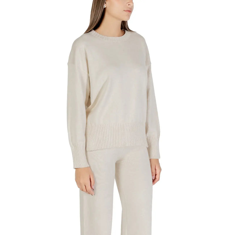 Pull Choral pour femme, en maille beige à col rond, confectionné en maille couleur crème à manches longues, avec ourlet et poignets côtelés.