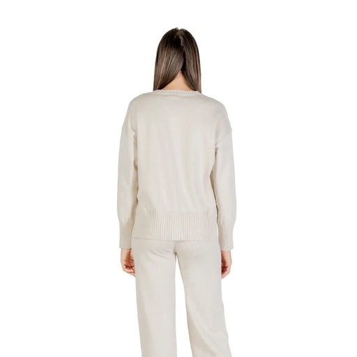 Pull Choral pour femme, en maille beige, col rond, manches longues, ourlet et poignets côtelés.