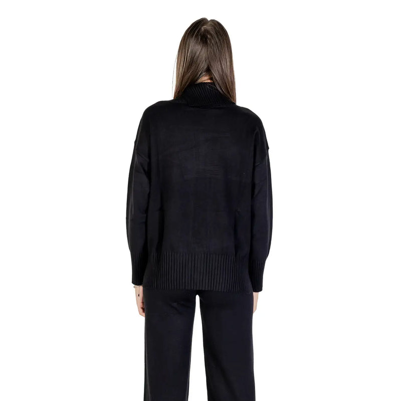 Pull noir à col roulé pour femme, en maille, avec poignets et ourlet côtelés, conçu pour allier chaleur et style.