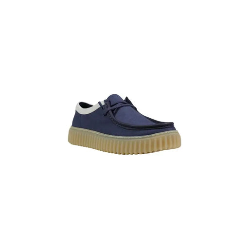 Chaussures à lacets Clarks pour homme, en toile bleue marine, modèle slip-on avec semelle en caoutchouc beige côtelé et finitions blanches.