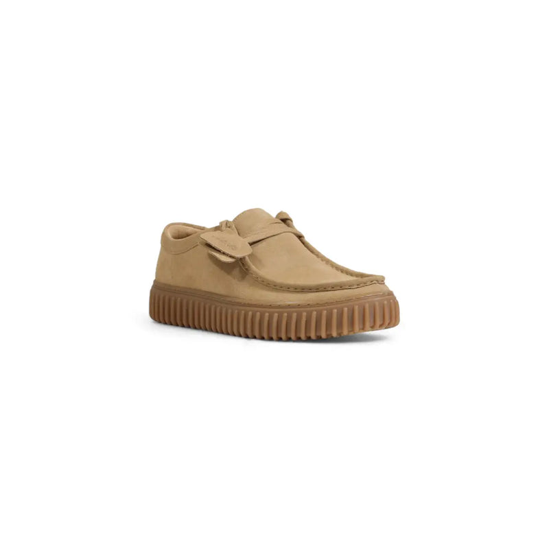 Mocassin Clarks pour homme en cuir beige et daim, avec semelle en caoutchouc côtelée et bride décorative sur le bout.