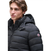 Doudoune Colmar Originals pour homme, noire, avec capuche matelassée et logo circulaire sur la manche, vue de face