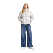 A woman wears a white quilted puffer jacket with silver patterns in the Columbia women beige polyester blazer jacket