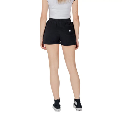 Vue arrière de converse Short en molleton de coton noir pour femme, orné d'un petit logo en forme de chevron avec étoile blanche sur la poche.