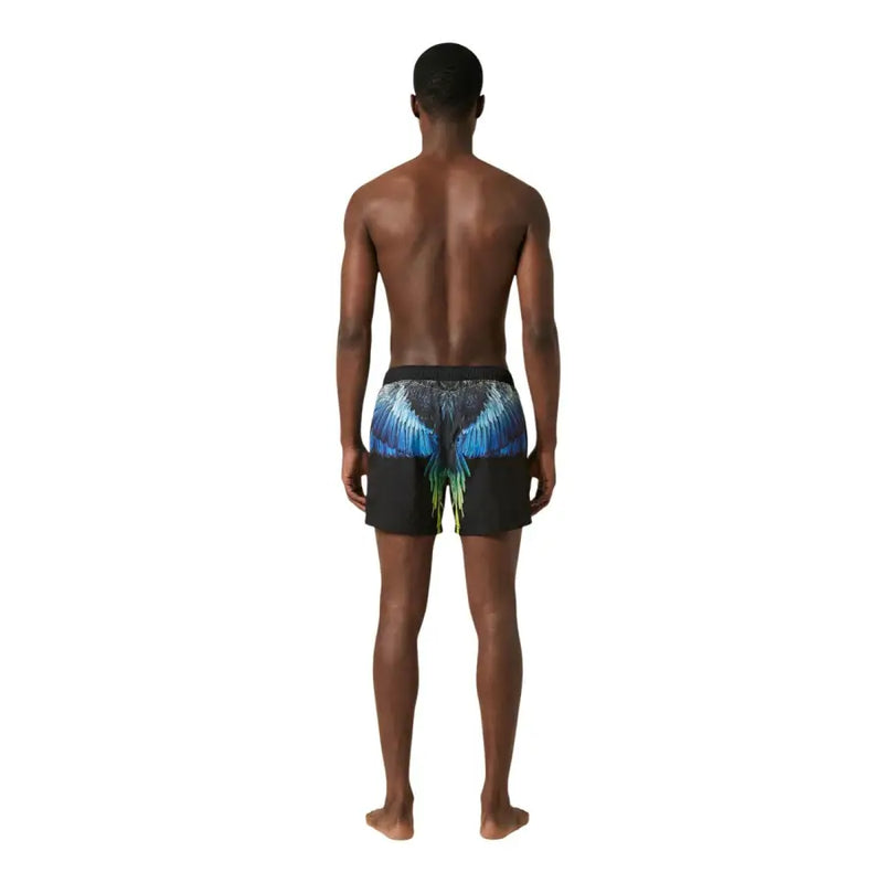 Vue arrière d'un short de bain homme County of Milan en polyester noir avec un motif d'ailes bleu et vert vif.