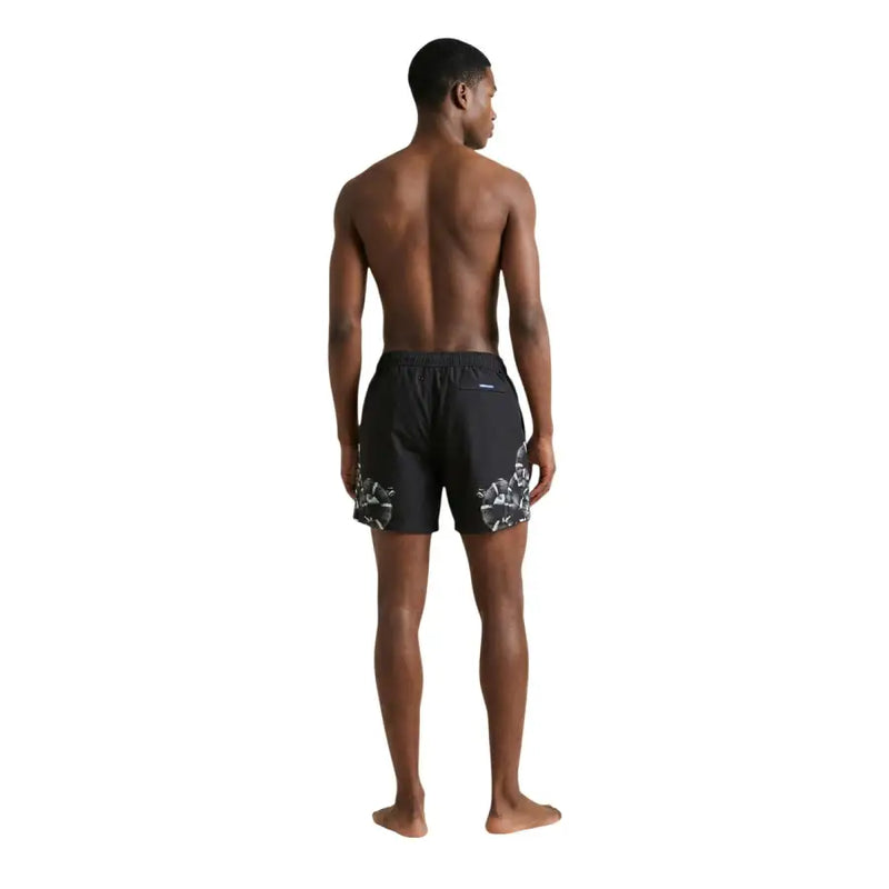 Black swim trunks by County of Milan featuring bold white floral pattern on lower legs suitable for men swimwear