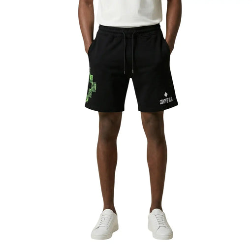 Short County of Milan pour homme en coton noir avec croix verte pixélisée et logo blanc, vue de face