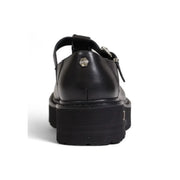 Back view of black leather Cult Women platform sandal with t-strap and silver hexagonal logo plaque on heel