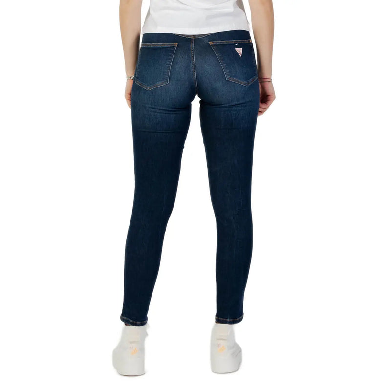 Dark wash skinny denim jeans in dark blue with a fitted cut and a small guess logo on the back pocket shown from the back