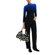 Pantalon Desigual pour femme en viscose noire avec poches, assorti à un sac bandoulière à motifs noirs et blancs orné de boucles de ceinture superposées.