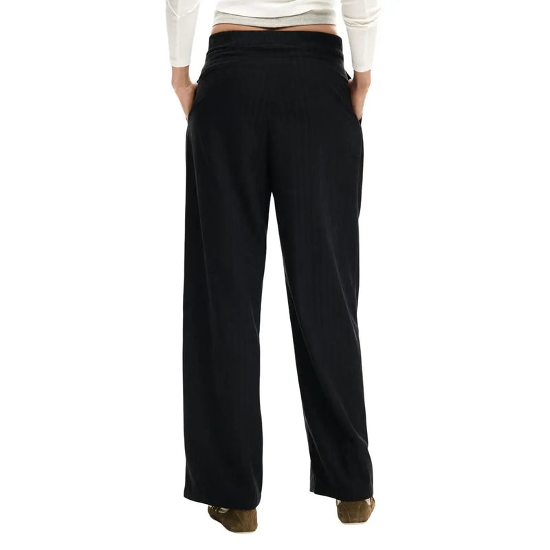 Pantalon Desigual noir à jambes larges et fermeture éclair pour femme, taille haute élastiquée et poches avant, en mélange de polyester.