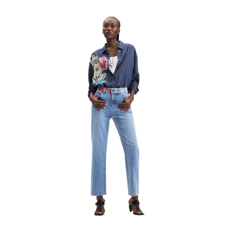 Chemise Desigual pour femme en denim de coton bleu avec broderie florale sur la manche gauche, idéale pour un style décontracté.