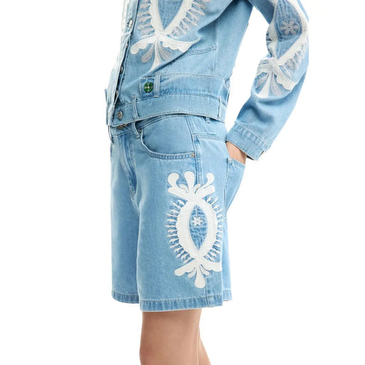 Short en denim bleu en coton Desigual pour femme, orné de broderies florales et de feuilles blanches délicates sur le devant et la cuisse.